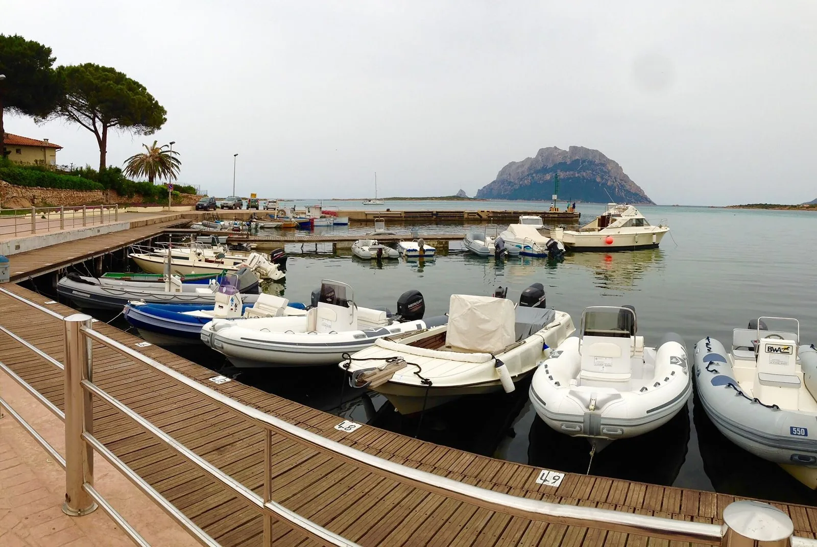 Il porticciolo di Porto San Paolo con le barche ormeggiate al pontile e l'isola di Tavolara sullo sfondo