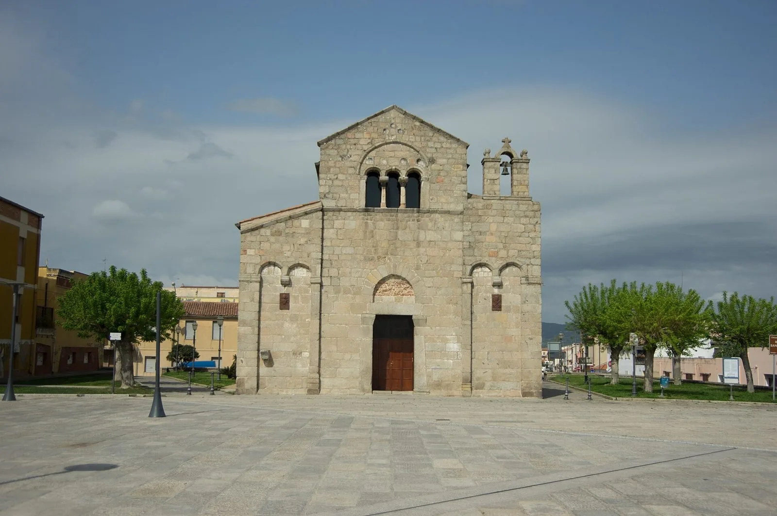 Facciata in granito della basilica romanica di San Simplicio a Olbia, con trifora e campanile a vela